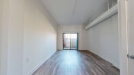 Located in the heart of Cincinnati's downtown at 221 W Fourth St, this two-bedroom, two-floor residence offers a well-organized and functional layout split evenly across both levels. The entrance leads into a welcoming hallway that connects the main living areas. The living room features light hardwood-style flooring and exposed beam detailing along the ceiling, lending an industrial-modern character to the space. Sliding glass doors open directly onto a private balcony, allowing natural light to fill the room and offering outdoor access.

The kitchen is well-appointed with rich dark cabinetry, granite countertops, stainless steel appliances including a range, microwave, refrigerator, and dishwasher, and light hardwood flooring. A carpeted staircase with a white handrail leads to the upper floor, where both bedrooms are located. The spacious primary bedroom includes a built-in closet and plush carpeting. The second bedroom is similarly carpeted and benefits from ample wall space. Three closets throughout the home provide generous storage. A clean, simply finished bathroom and a hallway complete the upper level. The space also includes two staircases for efficient vertical circulation throughout.
