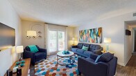 This single-floor, 2-bedroom, 2-bathroom residence offers a thoughtfully designed layout with distinct living, dining, and sleeping areas. The living room serves as the heart of the home, featuring wood-style flooring, a textured ceiling, and a sliding glass door that floods the space with natural light and leads to an outdoor patio. The open and inviting atmosphere is complemented by a wall-mounted television and ample room for seating arrangements.

Adjacent to the living area, the dining space features warm wood-style flooring and a bold accent wall, providing a vibrant and welcoming setting for meals. The kitchen is outfitted with white cabinetry, granite-style countertops, and black appliances, along with a louvered pantry door for additional storage.

Both bedrooms are carpeted and receive natural light through windows dressed with blinds and curtains. Each bedroom offers comfortable proportions suitable for a full or queen-sized bed and additional furnishings.

The two full bathrooms are finished with granite-style countertops, white cabinetry with brushed nickel hardware, wide vanity mirrors, and wood-style flooring — providing a clean and functional design throughout. The layout as a whole offers a practical and cohesive living environment.