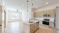 Located at 2220 Berryhill Road in Charlotte, NC, this thoughtfully designed one-bedroom, one-bathroom unit offers a clean, modern aesthetic across a single floor. Light wood-style flooring runs throughout, lending warmth and continuity to every room.

The heart of the unit is the open-concept living, dining, and kitchen area. The kitchen is equipped with light wood cabinetry featuring matte black hardware, light quartz countertops, a central island with an undermount sink, and a full suite of stainless steel appliances including a range, microwave, dishwasher, and refrigerator. Two pendant lights hang above the island, complementing the recessed ceiling lighting. The living area features a ceiling fan and a large window with blinds that brings in natural light.

The bedroom is a comfortable, well-proportioned space with a ceiling fan, a natural light-filled window, and direct access to a walk-in closet with built-in shelving. A second closet provides additional storage. The bathroom is outfitted with a full soaking tub and shower combo with white tile surround, accented by a curved matte black curtain rod and matching fixtures. The unit is rounded out by a dedicated laundry area and a utility room, offering practical convenience.