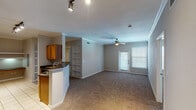 This single-story residence in Magnolia, Texas offers a practical and comfortable layout across two bedrooms and two full bathrooms. The open-concept living and dining area is finished with plush carpet, crown molding, and a ceiling fan, creating a welcoming atmosphere. Natural light filters in through blinded windows, and a door provides direct exterior access. Built-in shelving adds a functional architectural detail to the living space.

The galley-style kitchen features warm honey-toned cabinetry, dark countertops, tile flooring, and black appliances including a range, microwave, and refrigerator. Track lighting illuminates the workspace, and a curved breakfast bar with a sink connects the kitchen to the living area, enhancing the open feel.

Both bedrooms are carpeted and equipped with ceiling fans. One bedroom includes a window with outdoor views of mature trees. The two bathrooms are finished with tile flooring and neutral tones. One bathroom features a tub-shower combo with white tile surround and a grab bar, while the second offers a glass-enclosed standing shower, also with a grab bar for added accessibility.