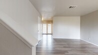 This two-story home offers a functional and well-organized layout across two floors, with the main living area on the ground floor and bedrooms situated above. The lower level features an open living room finished with durable hardwood-style flooring and a neutral color palette throughout. A standout feature is the French door entry, which floods the space with natural light and creates a welcoming entryway. A textured ceiling adds subtle character to the main living area.

The upper floor houses both bedrooms, each equipped with ceiling fans and hardwood-style flooring. The primary bedroom is generously sized, offering ample room for furnishings, and is complemented by a dedicated closet. Large windows in the bedrooms bring in abundant natural light and provide outdoor views. Each bedroom benefits from its own closet for additional storage convenience.

The two bathrooms are well-appointed; one features full tile surround walls and a soaking bathtub with tile flooring, while the other includes a vanity with a marble-style countertop, brushed nickel fixtures, and hardwood-style flooring. Neutral warm-toned walls are consistent throughout the home, lending a clean and cohesive aesthetic. The staircase connecting both floors is neatly integrated into the layout, making efficient use of the available space.