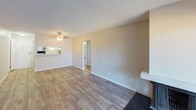 This single-floor residence offers a practical and well-appointed layout across several distinct areas. The living room serves as the central gathering space, featuring wood-style plank flooring, a textured ceiling, a ceiling fan with integrated lighting, and a baseboard heating system. A pass-through view into the kitchen adds an open, connected feel to the living area.

The galley-style kitchen is efficiently designed with white shaker cabinetry lining both sides, speckled quartz-style countertops, a stainless steel sink, electric range, and a full-size refrigerator. Wood-style flooring continues throughout this space, maintaining a cohesive aesthetic.

The bedrooms are carpeted and generously proportioned, each equipped with ceiling fans, baseboard heaters, and windows that allow natural light to filter in. One bedroom features a sliding-door closet with double hanging rods, providing practical storage.

The bathroom includes a speckled countertop vanity, wood-style flooring, a natural light window with blinds, and a baseboard heater. A separate area near the bathroom features built-in open shelving, ideal for additional storage needs.

Throughout the unit, neutral tones and clean white trim create a bright, move-in-ready atmosphere suited for everyday living.
