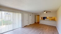 This single-floor, 3-bedroom, 2-bathroom unit in Gretna, Louisiana offers a practical and well-organized layout. The open living area features wood-look laminate flooring, a ceiling fan, and large vertical blinds covering a sliding door that allows for natural light. A pass-through counter connects the living space to the kitchen, creating an open feel between the two areas. The kitchen is fully equipped with white cabinetry, light countertops, a black electric range, a stainless steel refrigerator, and a tiled backsplash, all finished with wood-look flooring and a textured ceiling. A hallway leads from the living area to the bedrooms, each of which features plush carpeting, a ceiling fan with light fixture, and a window fitted with blinds for natural light and privacy. One bedroom features a distinctive painted brick accent wall, adding a unique textural element to the space. The bathrooms include a vanity with a light countertop, a large mirror, and chrome fixtures. Throughout the unit, textured ceilings and neutral wall tones create a cohesive, understated aesthetic. This unit provides a comfortable and efficiently designed living space in a convenient Gretna location.