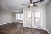 This single-floor residence offers a thoughtfully designed layout that balances comfort and functionality throughout. The open kitchen is a standout feature, showcasing gray shaker-style cabinetry, granite-look countertops, a classic subway tile backsplash, and a full suite of stainless steel appliances including a refrigerator, range, microwave, and dishwasher. Light wood-look flooring runs throughout the kitchen and flows seamlessly into the living area, which is bright and airy thanks to multiple windows and a set of glass patio doors that allow natural light to pour in. A ceiling fan adds to the comfort of the living space.

The bedrooms are generously sized, each featuring plush wall-to-wall carpeting, neutral-toned walls, and windows that provide natural light and outdoor views. One bedroom benefits from direct access to a private en-suite bathroom, lending a sense of privacy and convenience.

The two bathrooms are finished with matching gray cabinetry and light countertops. One bathroom features a walk-in shower with a handheld fixture, while the other offers a full shower-tub combination and notably includes a stacked washer and dryer unit, providing the added convenience of in-unit laundry. The overall aesthetic is clean, modern, and move-in ready.