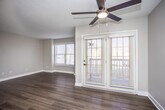 This single-floor residence offers a thoughtfully designed layout that balances comfort and functionality throughout. The open kitchen is a standout feature, showcasing gray shaker-style cabinetry, granite-look countertops, a classic subway tile backsplash, and a full suite of stainless steel appliances including a refrigerator, range, microwave, and dishwasher. Light wood-look flooring runs throughout the kitchen and flows seamlessly into the living area, which is bright and airy thanks to multiple windows and a set of glass patio doors that allow natural light to pour in. A ceiling fan adds to the comfort of the living space.

The bedrooms are generously sized, each featuring plush wall-to-wall carpeting, neutral-toned walls, and windows that provide natural light and outdoor views. One bedroom benefits from direct access to a private en-suite bathroom, lending a sense of privacy and convenience.

The two bathrooms are finished with matching gray cabinetry and light countertops. One bathroom features a walk-in shower with a handheld fixture, while the other offers a full shower-tub combination and notably includes a stacked washer and dryer unit, providing the added convenience of in-unit laundry. The overall aesthetic is clean, modern, and move-in ready.
