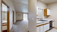 This one-bedroom, one-bathroom apartment in West Fargo, North Dakota offers a practical and comfortable single-floor layout. The open-concept kitchen and living area form the heart of the unit, with the kitchen featuring white cabinetry with wood-trimmed accents, white appliances including a dishwasher and refrigerator, a double sink, and light tile flooring. A pass-through window connects the kitchen to the living space, which is finished with plush carpet and highlighted by a sliding glass door that fills the room with natural light and provides access to an outdoor patio. The bedroom is a generously sized, carpeted retreat with a large window offering exterior views, baseboard heating, and direct access to a dedicated walk-in closet with wire shelving for organized storage. The full bathroom features tile flooring, a vanity with wooden trim, and a clean, neutral finish. A standout feature of this unit is the in-unit laundry area, equipped with washer and dryer hookups and additional wire shelving, adding everyday convenience. Throughout the unit, warm neutral tones, wood-trimmed doors, and consistent baseboard heating create a cohesive and functional living environment.