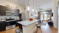 Located in Austin, TX (78736), this well-appointed one-bedroom, one-bathroom residence offers a thoughtfully designed open-concept layout across a single floor. The kitchen is a standout feature, showcasing bold navy cabinetry, a subway tile backsplash, granite countertops, and a full suite of stainless steel appliances including a refrigerator, range, microwave, and dishwasher. A peninsula-style granite island with pendant lighting above provides additional prep space and casual seating, flowing naturally into the living area. The living room is bright and welcoming, featuring hardwood-style flooring, a ceiling fan, and French doors that open to a private outdoor patio, allowing abundant natural light to fill the space. The bedroom continues the natural light theme with its own set of French doors offering outdoor access, complemented by plush carpeting and a dedicated closet. The bathroom features matching granite countertops, dark cabinetry, wood-look flooring, and a shower with a curtain enclosure. Throughout the residence, clean white walls and consistent finishes create a cohesive, modern aesthetic well-suited for comfortable everyday living in Austin.