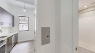 Located at 201 Cornelison Avenue in Jersey City, NJ, this well-designed one-bedroom, one-bathroom residence offers a thoughtfully organized layout on a single floor. Light-toned hardwood flooring runs throughout, complementing the crisp white walls and creating a clean, modern aesthetic.

The kitchen is a standout feature, outfitted with sleek dark wood cabinetry, white quartz countertops, a classic subway tile backsplash, and a full suite of stainless steel appliances including a refrigerator, gas range, microwave, and dishwasher. A window brings in natural light, enhancing the open feel of the cooking and dining area.

The bedroom is a bright, understated space with a window offering outdoor views and ample room for furnishings. Four closets distributed throughout the unit provide exceptional storage capacity rarely found in comparably sized spaces. In-unit laundry adds a layer of everyday convenience.

The bathroom features a tub-shower combination with white subway tile surround, a light wood vanity with white countertop, brushed gold fixtures, a mirrored medicine cabinet, and tile flooring, all contributing to a polished, contemporary finish. An electrical panel is discreetly integrated into the hallway. The overall ambiance is clean, functional, and modern.
