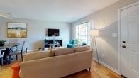 This two-floor residence offers a thoughtfully designed layout that balances comfort and functionality across its multiple rooms. The living area serves as a welcoming centerpiece, featuring warm parquet hardwood flooring, neutral walls, and large windows that invite abundant natural light and outdoor views. The space accommodates both relaxed seating and a distinct conversation nook, making it well-suited for everyday living and entertaining.

The kitchen is outfitted with rich cherry wood cabinetry, granite-style countertops, stainless steel appliances including a dishwasher and range, and a window above the sink that keeps the space bright and airy. A dedicated dining area with parquet flooring features wall art and a round mirror, adding character to the space.

The residence includes multiple bedrooms, each with hardwood flooring, ceiling fans, and windows dressed with light-filtering curtains. The primary bedroom offers a sliding mirror closet and a serene color palette. Additional bedrooms vary in size, with one featuring a vaulted ceiling and another offering a cozy, compact layout. Throughout, the home maintains a clean, neutral aesthetic with warm wood tones that create a cohesive and inviting ambiance across both floors.