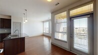 Located at 3650 S Broadway in Englewood, Colorado, this single-floor unit offers a thoughtfully designed open-concept layout that balances functionality with modern style. The living area is bright and welcoming, featuring warm hardwood-style flooring and large windows dressed with blinds that invite generous natural light and offer views of the surrounding neighborhood. A sliding door provides access to an outdoor area, further enhancing the sense of openness.

The kitchen is a standout feature, showcasing rich dark-stained cabinetry extending to the ceiling for ample storage, dark granite countertops, a light subway tile backsplash, and a full suite of stainless steel appliances including a refrigerator, electric range, and built-in microwave. A peninsula with a granite surface offers additional prep space and casual seating. Track and pendant lighting illuminate the kitchen and adjacent dining area effectively.

The bedroom is carpeted for comfort and includes a ceiling fan, a window with blinds, and a quiet, restful ambiance. The bathroom features a soaking tub and shower combination with full-height neutral tile surround and brushed nickel fixtures, delivering a clean and polished finish throughout. In-unit laundry connections are also present. The overall design is clean, contemporary, and move-in ready.