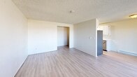 Located at 10625 22nd Pl S in Seattle, WA, this one-bedroom, one-bathroom unit offers a practical and efficiently arranged single-floor layout. The interior is finished with light-toned laminate flooring throughout the main living areas and a textured ceiling that adds a classic residential character. The open-concept living, dining, and kitchen area forms the heart of the unit, providing a cohesive space for everyday living and entertaining. The kitchen features white cabinetry and a stainless steel refrigerator, flowing seamlessly into the dining and living areas. A private patio extends the living space outdoors, offering a spot for fresh air and outdoor relaxation. The bedroom is a comfortable, carpeted retreat featuring a large sliding-door closet for ample storage and a window that brings in natural light with views of the surrounding area. A baseboard heating system is present in both the bedroom and living areas. An additional closet in the hallway provides further storage convenience. The bathroom includes a full bathtub and shower combination with tiled surround walls and a window for natural ventilation. The hallway entry connects all rooms in a straightforward layout, making the unit easy to navigate. Overall, the space presents a clean, neutral palette well-suited for personalization.