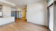 Located at 558 E Brooklyn Village Ave in Charlotte, NC, this one-bedroom, one-bathroom unit offers a well-designed open-concept layout across a single floor. The living area features light hardwood-style flooring, recessed lighting, and large floor-to-ceiling windows with transom panels that flood the space with natural light and open to a private balcony with city views. Stylish sliding barn doors connect the living area to the bedroom, adding a modern architectural touch.

The kitchen is thoughtfully appointed with gray shaker-style cabinetry extending to the ceiling, glass-front upper cabinets, white subway tile backsplash, quartz countertops, a center island with a stainless steel sink, and a full suite of stainless steel appliances including a side-by-side refrigerator with water dispenser, electric range, and built-in microwave. The kitchen flows seamlessly into the living area, making the space feel open and connected.

The bedroom is carpeted for comfort, features a ceiling fan, and connects to a dedicated closet. The bathroom is finished with large-format tile flooring, a white vanity with quartz countertops, a soaking tub with tiled surround, and a sleek gray panel door. The overall aesthetic is clean, contemporary, and move-in ready.