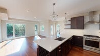 Located at 2804 W 43rd St in Minneapolis, this single-floor residence blends contemporary design with refined finishes throughout. The open-concept kitchen serves as the heart of the home, showcasing rich dark cabinetry, crisp white quartz countertops, and a generously sized central island with an integrated sink and built-in wine rack. A pair of elegant crystal pendant chandeliers anchors the space, adding a touch of glamour. Open shelving and a subway tile backsplash complement the stainless steel gas range and appliances, while the kitchen flows seamlessly into a bright, open living area. Multiple windows frame views of surrounding greenery, filling the space with abundant natural light and rich hardwood flooring throughout.

A well-proportioned hallway with sliding barn-style doors connects the living areas to the private quarters. The bedroom features plush carpeting, a ceiling fan, and a sun-filled window with outdoor views. A spacious walk-in closet outfitted with custom shelving and hanging rods provides ample organization. The bathroom is finished with large-format neutral tile surrounding a full soaking tub and shower combination with polished chrome fixtures, completing this well-appointed residence.