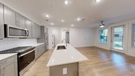 Located at 4115 Lake St in Alpharetta, GA, this well-appointed 2-bedroom, 2-bathroom residence offers a thoughtfully designed single-floor layout with generous living space. The open-concept kitchen and living area serves as the heart of the home, anchored by a large center island with a quartz countertop and undermount sink. The kitchen is outfitted with gray shaker-style cabinetry, white subway tile backsplash, and stainless steel appliances including a gas range, microwave, and refrigerator. Light hardwood flooring flows throughout, complementing the clean white walls and recessed lighting that keeps the space bright and welcoming. A ceiling fan in the living area adds comfort, while windows provide natural light and views of the landscaped courtyard below. The spacious primary bedroom includes direct balcony access and connects to a private bathroom. The second bedroom is well-sized with its own closet and ceiling fan. Both bathrooms are finished with gray vanities and subway tile surrounds. Three closets provide ample storage throughout. A dedicated laundry area houses a stacked washer and dryer unit. The private balcony overlooks a manicured courtyard with seating areas and greenery, offering a pleasant outdoor retreat in the heart of Alpharetta.