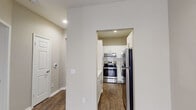 This single-story 1-bedroom residence in Dallas, TX offers a clean, modern aesthetic with thoughtfully selected finishes throughout. The open living and dining area is anchored by rich, dark hardwood-style flooring and neutral warm-toned walls, creating a bright and welcoming atmosphere. A window allows natural light to fill the space, enhancing its open feel.

The kitchen is efficiently designed with white shaker-style cabinetry, white subway tile backsplash, light countertops, and a full suite of stainless steel appliances including a range, refrigerator, and dishwasher. Dark hardwood-style flooring continues seamlessly into the kitchen, tying the space together cohesively.

The bedroom is generously proportioned, featuring plush carpeting, a ceiling fan with light fixture, and French doors that invite natural light and provide outdoor access. The neutral color palette throughout keeps the space feeling airy and versatile.

The bathroom is well-equipped with a white vanity featuring a vessel-style sink, light stone countertops, a full soaking tub with tiled surround, and matching dark hardwood-style flooring. Recessed lighting and a large mirror complete the clean, functional design. The hallway connecting the rooms provides ample storage access and a logical, easy-to-navigate flow throughout the residence.