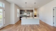 Located at 409 East Butler Avenue in New Britain, PA, this well-appointed 2-bedroom, 2-bathroom residence offers a clean, modern aesthetic across a single thoughtfully designed floor. The open-concept living and kitchen area serves as the heart of the home, featuring warm hardwood-style flooring, recessed lighting, and a bank of large windows that flood the space with natural light and offer pleasant outdoor views. The kitchen is a standout, equipped with rich dark-espresso cabinetry, stainless steel appliances, a subway tile backsplash, a large center island with a white countertop, and stylish pendant lighting overhead. Both bedrooms are carpeted for comfort, each featuring windows that bring in ample daylight. The primary bedroom provides a generous, well-proportioned retreat. Two full bathrooms are finished with large-format white tile flooring, dark vanity cabinetry, and white countertops. One bathroom features a soaking tub with shower combination, while the other offers a glass-enclosed walk-in shower. A dedicated closet adds practical storage. Neutral wall tones and clean trim work throughout lend the space a bright, move-in-ready feel.