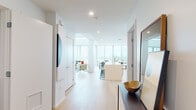 Located on Ocean Boulevard in downtown Long Beach, this two-floor residence offers a refined, contemporary living experience with sweeping panoramic views of the harbor and cityscape. Floor-to-ceiling glass windows and sliding doors flood the interior with natural light while framing the spectacular coastal scenery from nearly every angle.

The open-concept main living area flows seamlessly from the living room—anchored by soaring double-height windows—into the dining space and out to a private balcony, ideal for outdoor entertaining with unobstructed views. The chef's kitchen is sleek and functional, featuring light wood cabinetry paired with crisp white countertops, stainless steel appliances, a generous island with bar seating, and a dedicated prep sink along the galley-style perimeter.

Light hardwood flooring runs throughout, tying together the clean, minimalist aesthetic. The bedrooms are bright and well-proportioned, with crisp white walls that complement the natural light. A versatile flex room serves as an ideal home office or creative studio space. The bathrooms are finished with large-format neutral tiles and glass-enclosed walk-in showers. A dedicated laundry area adds everyday convenience. The residence delivers an elevated urban lifestyle in one of Long Beach's most prominent waterfront addresses.