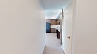 This well-designed single-floor unit offers a clean, contemporary aesthetic throughout, with light wood-look flooring in the main living areas and plush carpet in the bedrooms. The open-concept kitchen and living space serves as the heart of the unit, featuring warm wood-toned cabinetry, white countertops, recessed lighting, and black appliances including a refrigerator, range, and dishwasher. Ample upper and lower cabinet storage makes the kitchen as functional as it is stylish.

The bedrooms are bright and welcoming, each finished with soft neutral carpet and fitted with windows dressed in blinds that invite generous natural light while maintaining privacy. The primary bedroom benefits from multiple windows and direct access to a spacious walk-in closet outfitted with wire shelving on multiple levels for versatile organization.

The unit includes two bathrooms. The full bathroom features a wood-toned vanity with a white countertop, a large mirror with overhead lighting, and a tub-shower combination. The second bathroom is thoughtfully designed for accessibility, equipped with stainless steel grab bars and a similarly styled vanity. Both bathrooms feature light wood-look flooring that ties seamlessly into the overall design palette, creating a cohesive and move-in-ready living environment.