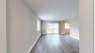 Located at 122 Pinewood Crescent in Yorktown, Virginia, this single-story 2-bedroom, 2-bathroom home offers a clean, modern aesthetic with thoughtfully updated finishes throughout. The open living and dining areas are anchored by durable wood-look plank flooring in a warm gray tone, neutral wall colors, and crisp white trim that together create a bright, cohesive atmosphere. Sliding glass doors in the living room invite natural light and provide direct access to an outdoor deck, further enhancing the sense of openness. The galley-style kitchen is well-equipped with white shaker cabinetry, brushed nickel hardware, light quartz countertops, a double stainless steel sink, and stainless steel appliances — all set over matching wood-look flooring. An adjacent dining area with a window adds practicality and natural light to the space. Both bedrooms are generously sized, featuring plush carpet, neutral tones, and ample natural light from well-placed windows. The spacious primary bedroom includes multiple closets for abundant storage. The bathrooms continue the home's clean design with wood-look flooring and light finishes. A dedicated utility room and five closets throughout the home provide exceptional storage. The layout flows efficiently through a connecting hallway, making the home functional and easy to navigate.