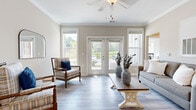 Model 330-100 is a thoughtfully designed single-story residence featuring two bedrooms and two bathrooms within a comfortable, efficiently arranged floor plan. The living room serves as a bright, welcoming centerpiece, finished with light wood-look plank flooring, crown molding, and a ceiling fan. Large windows and glass French doors flood the space with natural light and provide direct access to an outdoor balcony, offering pleasant outdoor views. The open layout connects the living area to the dining space and kitchen seamlessly.

The kitchen features rich, dark cabinetry paired with granite countertops, stainless steel appliances, and a peninsula that doubles as a breakfast bar. Light tile flooring carries through the dining area, where crown molding and a clean entryway add a polished finish.

The spacious primary bedroom offers ample room for furnishings and connects to a dedicated closet outfitted with multi-level wire shelving for generous storage. The bathrooms are finished with granite-topped vanities, tile flooring, and natural light from windows. A dedicated laundry room accommodates a full-size washer and dryer. Neutral wall tones throughout lend the entire residence a cohesive, calm ambiance.
