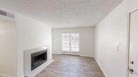 Located in Scottsdale, Arizona, this single-floor, 3-bedroom, 2-bathroom home offers a functional and well-organized layout across a compact yet efficiently designed floor plan. The living room serves as the heart of the home, featuring a tile-surround fireplace, wood-look flooring, a textured ceiling, and a set of French doors that invite natural light and provide access to the outdoors. An adjacent dining area also benefits from French doors, further enhancing the connection between indoor and outdoor living. The galley-style kitchen is efficiently arranged with gray cabinetry lining both sides, light countertops, a stainless steel sink, and white appliances including a range and refrigerator, all set over wood-look flooring. The three bedrooms are carpeted and receive natural light through blinded windows offering views of the surrounding landscaped grounds. Ceiling fans are present in the bedrooms, adding comfort in the Arizona climate. The two bathrooms are clean and functional; one features a tub-shower combo with white tile surround, while the other includes a wide vanity with a large mirror and extended countertop. Neutral tones and light-colored walls throughout create a bright, cohesive ambiance.