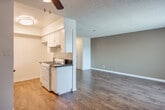 Located at 12450 Lakewood Blvd in Downey, California, this single-floor unit offers a practical and well-appointed layout. The open-concept living and dining area is finished with rich, dark hardwood-style flooring and features a ceiling fan, a large window with vertical blinds that allows natural light to fill the space, and a wall-mounted air conditioning unit. Neutral warm-toned accent walls complement the crisp white trim throughout.

The galley-style kitchen is efficiently designed with white cabinetry, dark granite-style countertops, a gas range, and a stainless steel sink. The wood-toned flooring continues into the kitchen, and ample upper and lower cabinet storage makes the space highly functional.

The bedroom is generously sized, finished with plush wall-to-wall carpeting, a ceiling fan with light fixture, and a mirrored sliding-door closet that adds depth to the room. A window provides additional natural light, and warm tan accent walls create a comfortable ambiance.

The bathroom features a tub-shower combination with sliding glass doors, a vanity with dark granite-style countertops, white cabinetry, a large mirror, and hardwood-style flooring, tying together the consistent design language found throughout the unit. Textured ceilings are present throughout the space.