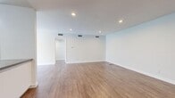 This single-floor residence offers 2 bedrooms and 3 bathrooms with a clean, modern aesthetic throughout. The open-concept living and dining area is bright and spacious, featuring warm wood-tone laminate flooring, recessed lighting, and a ceiling fan, with large windows and a sliding glass door that bring in generous natural light. The kitchen is well-equipped with white shaker-style cabinetry extending to the ceiling for ample storage, gray countertops with a peninsula breakfast bar, and a full suite of stainless steel appliances including a refrigerator, gas range, and built-in microwave. Both bedrooms are carpeted and generously sized, with the primary bedroom offering a notably expansive layout and a mirrored sliding-door closet. The second bedroom also features a large window with vertical blinds and direct access to a bathroom. The three bathrooms are finished with white cabinetry, gray countertops, undermount sinks, and wood-look flooring, reflecting a cohesive design sensibility. A dedicated hallway connects the living spaces to the bedrooms, and a closet provides additional storage. The overall ambiance is light, clean, and move-in ready, with a neutral color palette that lends itself well to a variety of interior styles.