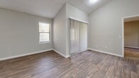 Located at 3925 Satellite Blvd in Duluth, GA, this single-floor, 2-bedroom, 2-bathroom home offers a thoughtfully organized layout with a clean, modern aesthetic throughout. The kitchen is a standout feature, showcasing white shaker-style cabinetry with brushed nickel hardware, light quartz countertops, a subway tile backsplash, and stainless steel appliances, all set atop wood-look plank flooring that flows through the main living areas. The spacious primary bedroom features vaulted ceilings, large windows that invite natural light, wood-look flooring, and access to a sliding door with vertical blinds. It is complemented by a generously sized walk-in closet with wire shelving. The second bedroom is finished with neutral carpet and offers a quiet, functional space. Both bathrooms are appointed with wood-look tile flooring; one includes a full soaking tub and shower combination. A dedicated laundry room houses a full-size washer and dryer with overhead wire shelving for additional storage. Throughout the home, neutral gray and beige tones, textured ceilings, and white trim create a cohesive and clean ambiance suited for comfortable everyday living.