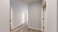 Located at 1 W Quincy St in Westmont, IL, this thoughtfully designed one-bedroom, two-bathroom unit offers a well-appointed single-floor layout with modern finishes throughout. The open-concept kitchen and living area serves as the heart of the space, featuring a large peninsula with granite-look countertops, a two-tone cabinet scheme pairing crisp white uppers with warm wood-toned lowers, stainless steel appliances including a gas range and French door refrigerator, and pendant lighting overhead. Light wood-tone luxury vinyl plank flooring flows seamlessly through the main living areas, complementing the neutral gray walls and clean white trim. The living area extends to a private balcony through a sliding glass door, allowing natural light to fill the room. The carpeted bedroom offers a comfortable retreat with a bright window and ample wall space. Two full bathrooms are included — one featuring a floating wood-toned vanity with stone countertop, tall storage cabinet, and a soaking tub. A dedicated laundry room houses a full-size washer and dryer. Two closets provide generous storage. Black hardware accents on interior doors add a contemporary touch throughout this clean, modern space.