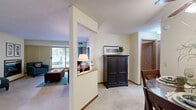 Located at 1480 Park St in White Bear Lake, Minnesota, this well-appointed 2-bedroom, 3-bathroom residence offers a comfortable and functional single-floor layout. The open-concept living and dining area serves as the heart of the home, featuring plush carpeting, a fireplace, and large sliding glass doors that flood the space with natural light and provide access to a private patio. A ceiling fan highlights the dining area, which comfortably accommodates a full dining set. The living room's expansive window frames tree-lined outdoor views, enhancing the warm, inviting ambiance throughout.

The kitchen is efficiently designed with warm wood cabinetry, ample overhead storage, tile flooring, and a wraparound peninsula with bar seating — ideal for casual dining or entertaining. A partial dividing wall separates the kitchen from the living area while maintaining an open feel.

The generously sized primary bedroom offers dual closets and plenty of room to furnish comfortably. The second bedroom is bright and well-proportioned. Three bathrooms — including a combined bathroom and laundry room — provide excellent convenience. Eight closets throughout the unit ensure abundant storage. A utility room rounds out the practical offerings of this thoughtfully designed home.