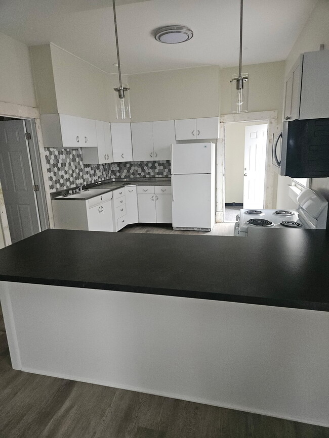 Tiled backsplash that accents the refurbished 1950s vintage metal cabinets. Refrigerator present and - 728 S 15th St