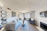 Located at 2700 Central Drive in Bedford, TX, this one-bedroom, one-bathroom residence offers a well-organized single-floor layout that makes efficient use of its space. The living room serves as the heart of the home, featuring plush carpeting, large windows that invite ample natural light, a sliding glass door, and a classic fireplace — creating a warm and inviting atmosphere. A wall-mounted mini-split unit provides additional climate control comfort.

The galley-style kitchen is thoughtfully appointed with dark espresso cabinetry, granite countertops, a subway tile backsplash, stainless steel appliances including a full-size refrigerator and electric range, and a pass-through breakfast bar that connects to the dining area — ideal for casual meals and entertaining.

The bedroom is generously proportioned, offering soft carpeting, two windows that bring in natural light, and direct access to the bathroom, which features a full tub and shower combination with white tile surround and wood-look flooring.

Throughout the unit, neutral gray walls and textured ceilings provide a clean, cohesive backdrop. The practical layout, combined with functional finishes and comfortable living spaces, makes this a well-rounded residence in the heart of Bedford.