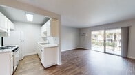 Located at 10108 Calle Marinero in Spring Valley, California, this single-floor unit offers a clean, modern aesthetic throughout. The open-concept living area is anchored by warm wood-style flooring and soft neutral-toned walls, creating a bright and welcoming atmosphere. A wall-mounted air conditioning unit provides climate control, while sliding glass doors lead to a private balcony that frames pleasant outdoor views of the surrounding neighborhood and hillside scenery.

The galley-style kitchen is efficiently designed with white cabinetry, light stone-finish countertops, a gas range, a full-size refrigerator, and a double sink — all thoughtfully arranged to maximize functionality. A skylight above the kitchen passthrough adds a touch of natural brightness to the cooking area.

The two bedrooms are finished with plush wall-to-wall carpeting and neutral walls, offering a comfortable and quiet retreat. One bedroom features a window with a scenic view, allowing natural light to fill the space. The full bathroom is finished in clean white tones, complete with a tub/shower combination, a vanity with a granite-style countertop, and wood-look flooring that ties the space together cohesively.