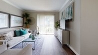 This single-story residence is thoughtfully designed to maximize functionality and comfort throughout its layout. The living room serves as a welcoming centerpiece, featuring rich hardwood-style flooring, crown molding, and a sliding glass door with vertical blinds that invites abundant natural light and provides access to an outdoor balcony. A dedicated media wall and tasteful wall art contribute to the room's polished aesthetic.

The kitchen flows seamlessly from the living area and is outfitted with dark espresso cabinetry, granite-style countertops, a stainless steel sink, and a black dishwasher. A natural light source brightens the workspace, making it both practical and pleasant.

The bedrooms offer plush wall-to-wall carpeting, ceiling fans, and ample natural light through blinds-covered windows. The primary bedroom connects directly to the bathroom, providing convenient private access.

The bathroom is well-equipped with dark cabinetry, a granite-style vanity countertop, a framed mirror with overhead lighting, and a shower with a decorative curtain. A notable feature is the in-unit stacked washer and dryer, integrated seamlessly within the bathroom space. Hardwood-style flooring carries throughout the non-carpeted areas, maintaining a cohesive and modern aesthetic across the residence.