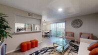 This thoughtfully designed one-bedroom, one-bathroom residence offers a functional and stylish single-floor layout. The open-concept living and dining area serves as the heart of the home, featuring light wood-style flooring, a textured ceiling, and recessed lighting. The living room provides a comfortable gathering space, with a sliding glass door fitted with vertical blinds that opens directly to a private balcony, allowing natural light to flow in. The dining area is highlighted by a contemporary ring pendant light and a second sliding glass door offering continued outdoor access and views.

The kitchen is efficiently arranged in a galley style, outfitted with stainless steel appliances, including a full-size refrigerator and dishwasher, complemented by light cabinetry with dark hardware and a stone-look countertop with a pass-through window to the dining area.

The bedroom is a calm retreat finished with plush carpeting, neutral wall tones, and ample space for furnishings. A dedicated closet provides convenient storage. The bathroom features wood-look flooring, a combined tub and shower with tile surround, and a vanity with a granite-style countertop and dark cabinetry. A hallway connects all areas of the residence, completing this cohesive and well-organized layout.