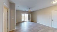 Located at 12201 Avoca Rd in Louisville, KY, this single-story unit offers a well-designed, functional layout with consistent finishes throughout. Light-toned hardwood-style flooring flows seamlessly across the main living and bedroom areas, creating a cohesive and clean aesthetic.

The living area is bright and open, featuring a ceiling fan and glass French doors that lead to a private balcony, allowing natural light to fill the space. A half-wall separates the living area from the kitchen, providing an open-concept feel while maintaining defined zones. The galley-style kitchen is outfitted with dark espresso cabinetry, white countertops, a subway tile backsplash, and a full suite of stainless steel appliances, including a refrigerator, range, microwave, and dishwasher.

The bedroom offers a ceiling fan, a window with blinds framing outdoor views, and direct access to additional spaces. A dedicated laundry area houses a full-size washer and dryer. The bathroom is finished with tile flooring, a dark vanity with a white countertop, a large mirror, and a glass-enclosed walk-in shower, providing a clean and practical design throughout.