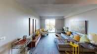 This single-floor residence offers a thoughtfully designed layout with a cohesive, contemporary aesthetic throughout. The living room serves as the centerpiece of the space, featuring light hardwood-style flooring, a textured ceiling, and a large sliding glass door that opens to a private balcony with outdoor views, filling the room with natural light. The area comfortably accommodates generous seating arrangements and decorative furnishings, creating a warm and inviting atmosphere.

The kitchen is outfitted with dark espresso cabinetry, granite countertops, and a full suite of stainless steel appliances, including a range, microwave, dishwasher, and refrigerator. The hardwood-style flooring continues here, lending a consistent, polished look throughout the common areas.

The bedroom is carpeted for comfort and features wide windows with blinds that bring in ample natural light. The room provides a calm, restful environment with enough space for a full bedroom set and additional furnishings.

The bathroom is finished in a clean, bright style with white cabinetry, a large vanity mirror, and a tub-shower combination. Wood-style flooring and crisp white fixtures complete the polished look. Overall, the space balances modern finishes with functional design for comfortable everyday living.