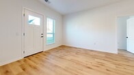 This contemporary apartment, located at Unit #106 Building SF1 in Hartland, WI, offers an impressive 2,940 square feet of living space. The floor plan features two bedrooms, including a spacious primary bedroom of 160 square feet, and two full bathrooms. The open-concept design seamlessly integrates the kitchen and living room, creating a fluid and expansive feel.

Throughout the apartment, light oak hardwood flooring adds warmth and elegance. Large windows with horizontal blinds flood the rooms with natural light and provide views of the surrounding area. The kitchen boasts sleek white cabinetry, stainless steel appliances, and granite countertops, complemented by pendant lighting over a central island.

Both bathrooms feature modern fixtures, including glass-enclosed showers and built-in storage. The laundry room is equipped with new Whirlpool washer and dryer units. The apartment's entryway showcases a stylish white door with a glass panel, welcoming residents and guests alike.

This single-story unit combines contemporary design with practical amenities, offering a comfortable and stylish living space in a desirable location.