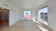 This contemporary apartment in Boise, Idaho, offers 940 square feet of thoughtfully designed living space. The two-bedroom, two-bathroom layout maximizes functionality while maintaining an open, airy feel. The heart of the home is a sleek, modern kitchen featuring clean-lined cabinetry, stainless steel appliances, and a practical island that doubles as a breakfast bar.

Large windows flood the living areas with natural light and provide stunning views of the cityscape, including a vibrant mural visible from the apartment. The primary bedroom, measuring 140 square feet, offers ample space for relaxation. Both bathrooms are outfitted with modern fixtures, including a combination tub-shower unit.

Throughout the apartment, light-toned wood flooring creates a warm, inviting atmosphere that contrasts beautifully with the crisp white walls. Recessed lighting and a stylish ceiling fan in the main living area add both functionality and visual interest.

The apartment's single-floor layout eliminates the need for stairs, enhancing accessibility. A dedicated laundry area and closet space provide essential storage solutions. The overall design emphasizes a minimalist aesthetic, creating a canvas for personal style while maintaining a fresh, contemporary ambiance perfect for urban living.