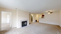 Located at 359 N West St in Indianapolis, Indiana, this 2-bedroom, 2-bathroom residence offers a well-designed single-floor layout. The open-concept living area is anchored by a tile-surround wood-burning fireplace and flows seamlessly toward a sliding glass door that opens to a private balcony, filling the space with natural light and neighborhood views. A ceiling fan adds comfort to the living area. The kitchen features rich wood cabinetry, granite countertops, a peninsula with a double sink, and direct sight lines into the living space — ideal for both everyday living and entertaining. Both bedrooms are carpeted and bathed in natural light through large windows with views of the surrounding area. The primary bedroom includes a walk-in closet with wire shelving for ample storage. Each of the two bathrooms is equipped with a full tub-and-shower combination with tiled surrounds. Additional conveniences include a dedicated laundry area, a utility room, and four closets throughout the unit. Textured ceilings and neutral tones create a clean, consistent aesthetic throughout, while carpeted floors provide warmth across the living and sleeping areas.