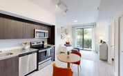 This thoughtfully laid-out 2-bedroom, 2-bathroom residence in Goulds, FL offers a modern and cohesive design throughout its single-floor layout. The open-concept kitchen and living area serves as the heart of the home, where rich dark-wood cabinetry, granite countertops, and a full suite of stainless steel appliances—including a refrigerator, range, microwave, and dishwasher—create a sleek, functional kitchen. Light wood-style flooring flows seamlessly into the dining and living areas, which are bathed in natural light from large sliding glass doors that open to a private patio with lush outdoor views. Both bedrooms are comfortably sized and feature large windows with natural light, dedicated closets with wire shelving, and easy access to the two full bathrooms. Each bathroom is finished with dark-wood vanities, granite countertops, a tub-shower combination, and light flooring that maintains a clean, modern aesthetic. The unit also includes an in-unit laundry area and a utility room, adding everyday convenience. Bright white walls, track lighting, and consistent flooring throughout give the space a fresh, cohesive feel well-suited for comfortable living in South Florida.