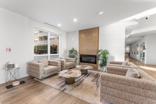 Inviting lounge area with cozy seating, stylish marble tables, and a modern fireplace, perfect for relaxation and entertaining. - Triton Cay - Daytona Apartments