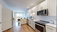 This well-appointed one-bedroom, one-bathroom residence in Centennial, Colorado offers a thoughtfully designed open-concept layout that maximizes its efficient footprint. Warm wood-style flooring flows throughout the main living areas, creating a cohesive and inviting atmosphere.

The kitchen is a standout feature, showcasing crisp white shaker cabinetry, white subway tile backsplash, light quartz countertops, and a full suite of stainless steel appliances including a dishwasher, range, microwave, and refrigerator. The kitchen opens seamlessly into the living area, which benefits from abundant natural light and direct access to a private balcony with outdoor views.

The bedroom is a comfortable retreat, featuring plush carpeting, a ceiling fan, and large windows and balcony access that bring in generous natural light and outdoor scenery. Two closets provide ample storage throughout the unit.

The full bathroom is finished with classic white subway tile surrounding the soaking tub and shower, complemented by a white vanity and hardwood-style flooring. Conveniently, an in-unit stacked washer and dryer is located adjacent to the bathroom, adding a practical and desirable amenity. The overall ambiance is clean, modern, and bright.