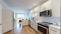 This well-appointed one-bedroom, one-bathroom residence in Centennial, Colorado offers a thoughtfully designed open-concept layout that maximizes its efficient footprint. Warm wood-style flooring flows throughout the main living areas, creating a cohesive and inviting atmosphere.

The kitchen is a standout feature, showcasing crisp white shaker cabinetry, white subway tile backsplash, light quartz countertops, and a full suite of stainless steel appliances including a dishwasher, range, microwave, and refrigerator. The kitchen opens seamlessly into the living area, which benefits from abundant natural light and direct access to a private balcony with outdoor views.

The bedroom is a comfortable retreat, featuring plush carpeting, a ceiling fan, and large windows and balcony access that bring in generous natural light and outdoor scenery. Two closets provide ample storage throughout the unit.

The full bathroom is finished with classic white subway tile surrounding the soaking tub and shower, complemented by a white vanity and hardwood-style flooring. Conveniently, an in-unit stacked washer and dryer is located adjacent to the bathroom, adding a practical and desirable amenity. The overall ambiance is clean, modern, and bright.