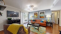 This single-floor, two-bedroom, two-bathroom residence at The Abbys At Inverness in Birmingham, Alabama, offers a well-designed layout that balances comfort and functionality. The living room serves as the central gathering space, featuring hardwood-style flooring, crown molding, a textured ceiling with a ceiling fan, and a bold blue-gray accent wall. A large sliding glass door floods the room with natural light and opens directly onto a private balcony with outdoor views of surrounding greenery, creating a seamless indoor-outdoor connection.

The kitchen is equipped with stainless steel appliances, including a range and over-the-range microwave, complemented by dark espresso cabinetry, granite-style countertops, and a classic white subway tile backsplash. Both bedrooms feature plush carpeting and ceiling light fixtures. One bedroom showcases a warm yellow accent wall, while the second features neutral tones with ample natural light from a large window.

Each of the two bathrooms is finished with dark wood vanity cabinetry, granite-style countertops, and tile flooring. One bathroom features a tub-shower combination, while the other offers a spacious vanity area. Together, these rooms create a cohesive, modern living environment with consistent, quality finishes throughout.