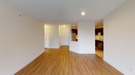 This single-floor residence offers a thoughtfully designed layout with a blend of comfort and functionality throughout. The open living area is finished with warm hardwood-style flooring and neutral tones, creating a bright and welcoming atmosphere. A sliding glass door leads to a private balcony, filling the space with natural light and offering outdoor views. The kitchen is a standout feature, equipped with rich dark wood cabinetry, stainless steel appliances including a refrigerator, range, microwave, and dishwasher, complemented by clean light countertops and a pass-through opening that connects to the living area. The bedrooms are generously sized, finished with plush carpeting and textured ceilings, each featuring windows with blinds that invite natural light and views of the surrounding greenery. Two full bathrooms serve the residence — one features a dark wood vanity with a large mirror and a tiled tub-shower combination, while the second offers a clean, streamlined design with a tub-shower and towel bar. Throughout the space, a consistent palette of soft whites and warm wood tones contributes to a cohesive, comfortable, and move-in-ready environment.