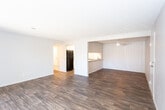 Located at 825 Calle Mejia in Santa Fe, New Mexico, this single-floor residence offers a thoughtfully laid-out interior with a clean, neutral aesthetic throughout. The open living area is highlighted by rich, dark hardwood-style flooring, a ceiling fan, and a sliding glass door fitted with vertical blinds that fills the space with natural light and provides access to the outdoors. Adjacent to the living area is a well-appointed galley kitchen featuring white shaker-style cabinetry with brushed nickel hardware, light countertops, a tile backsplash, a stainless steel sink, and black appliances including a refrigerator, dishwasher, and range. The bedrooms are carpeted in warm neutral tones and offer ample natural light through windows with blinds. Each bedroom is equipped with mirrored sliding closet doors that enhance the sense of space. The bathrooms include wood-style flooring, white vanity cabinetry, a medicine cabinet mirror, and a tiled shower-tub combination. Textured ceilings are present throughout the unit, contributing to the home's understated, functional character. The overall layout, as revealed by the dollhouse view, provides a well-connected, single-level floor plan suited for comfortable everyday living.