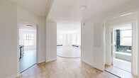 Located at 111 East Ave in downtown Rochester, NY, this 2-bedroom, 1-bathroom residence offers a well-designed layout filled with natural light and thoughtful finishes throughout. The living room is a standout space, featuring light hardwood flooring, a classic white-mantled fireplace, and a distinctive curved raised platform that adds architectural character. Large multi-pane windows frame views of the surrounding cityscape and treetops, flooding the room with sunlight. The galley-style kitchen is fully equipped with stainless steel appliances, crisp white cabinetry with matte black hardware, and elegant marble-look quartz countertops — all complemented by the same light hardwood flooring that flows throughout the unit. The spacious primary bedroom offers generous proportions, large windows with city views, and a dedicated walk-in closet with built-in shelving. The second bedroom also benefits from ample natural light and hardwood floors. The bathroom is a bold design statement, fully clad in vibrant blue mosaic tile from floor to ceiling, and featuring a soaking tub with overhead shower and a natural light window. Two hallways and a dedicated closet provide practical storage and connectivity throughout the home, completing this well-appointed residence.