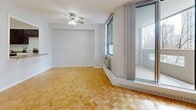 Located at 1423 Mississauga Valley Blvd in Mississauga, Ontario, this 2-bedroom, 1-bathroom residence offers a comfortable and practical layout across a single floor. The unit is characterized by gleaming parquet wood flooring that flows consistently throughout the living areas and bedrooms, lending warmth and visual continuity to the space.

The living room is generously sized, featuring a ceiling fan, a large sliding glass door that connects to a private balcony, and a baseboard heating unit. The balcony offers open views of the surrounding neighbourhood and nearby greenery. The combined kitchen and living area provides a functional transition space, with the kitchen showcasing rich dark-stained wood cabinetry, granite-style countertops, a classic white subway tile backsplash, and light ceramic tile flooring.

The spacious primary bedroom comfortably accommodates large furnishings and benefits from natural light through a window with urban views. The second bedroom also features parquet flooring, a built-in closet, and neutral tones throughout. The bathroom is finished with full-surround beige tile in the tub and shower area, offering a clean and classic aesthetic.

The unit's neutral colour palette and consistent finishes throughout create a cohesive, move-in-ready environment in a well-established Mississauga community.