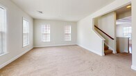 Located at 124 Cabot Alley in Mechanicsburg, Pennsylvania, this three-bedroom, two-bathroom residence is thoughtfully organized across three floors. The ground level features a garage with a concrete floor and standard overhead door, providing secure parking and additional storage space.

The main living floor offers a generously sized open layout with plush carpeting, multiple windows that draw in natural light, and a staircase with a wood railing. The kitchen is a standout feature, showcasing rich cherry wood cabinetry with crown molding detail, a large granite-topped island with a built-in sink, hardwood flooring, and black Whirlpool appliances including a side-by-side refrigerator, electric range, and over-the-range microwave.

The upper floor houses all three bedrooms, including a spacious primary bedroom with a walk-in closet fitted with wire shelving systems. The additional bedrooms feature plush carpeting and double-door closets. Two full bathrooms serve the upper level, each equipped with a tub-shower combination and clean, neutral finishes. Throughout the home, neutral wall tones and consistent trim work create a cohesive and functional living environment.
